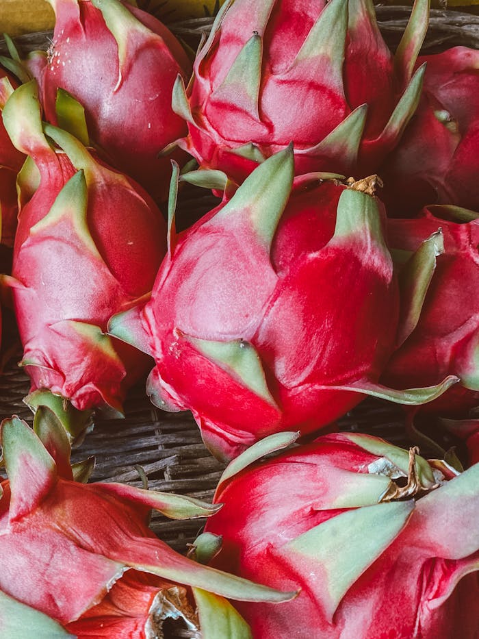 Vibrant vertical shot showcasing organic dragon fruits in a basket.